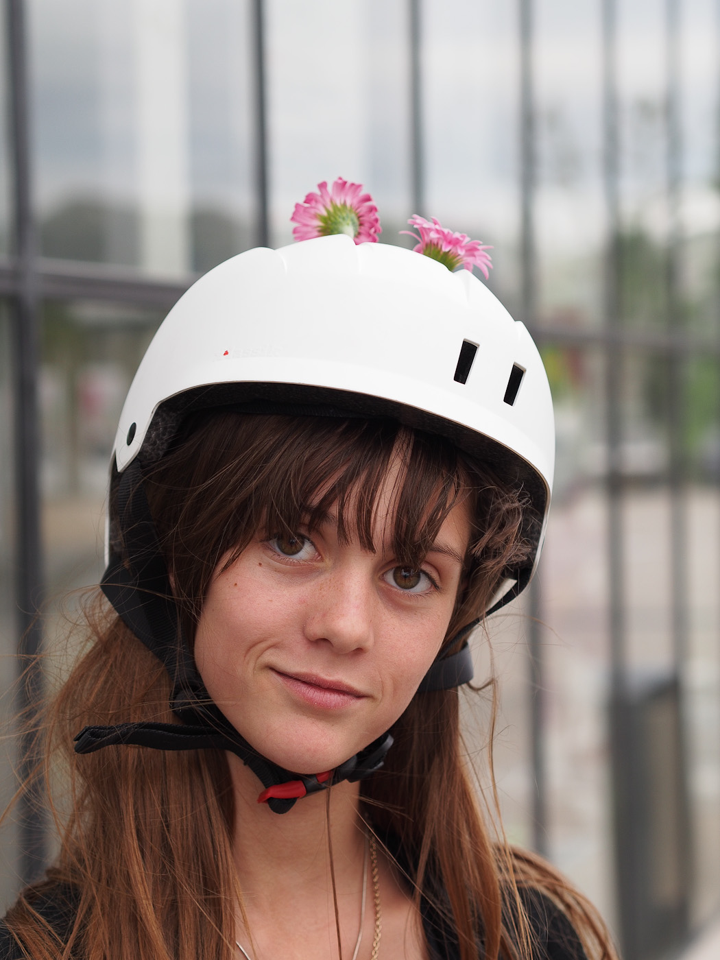 A young rollerskater girl has flowers sticking out of her helmet. Olympus OM-D E-M5 & Olympus Digital Zuiko 45mm f1.8